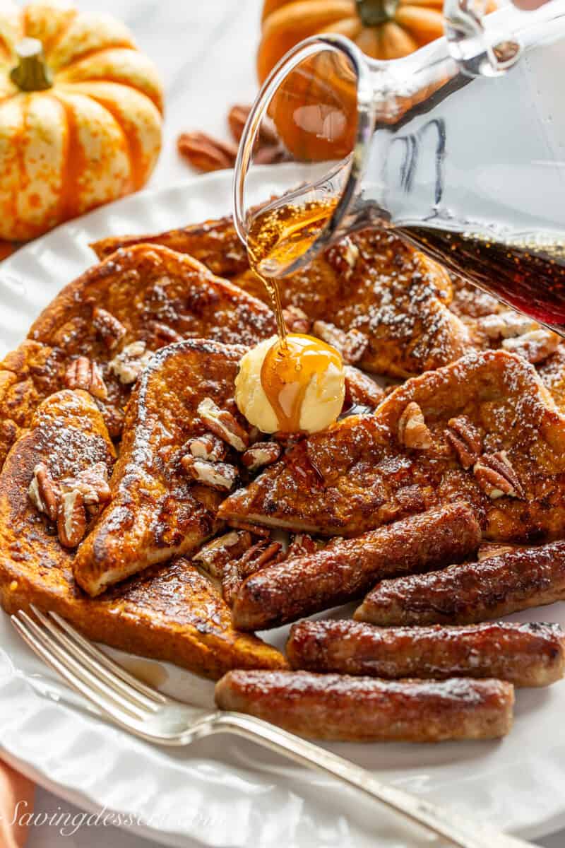 A plate of french toast wedges being drizzled with maple syrup.