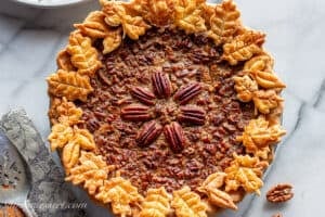An overhead view of a pecan pie with cookie crust cutouts in the shape of leaves.