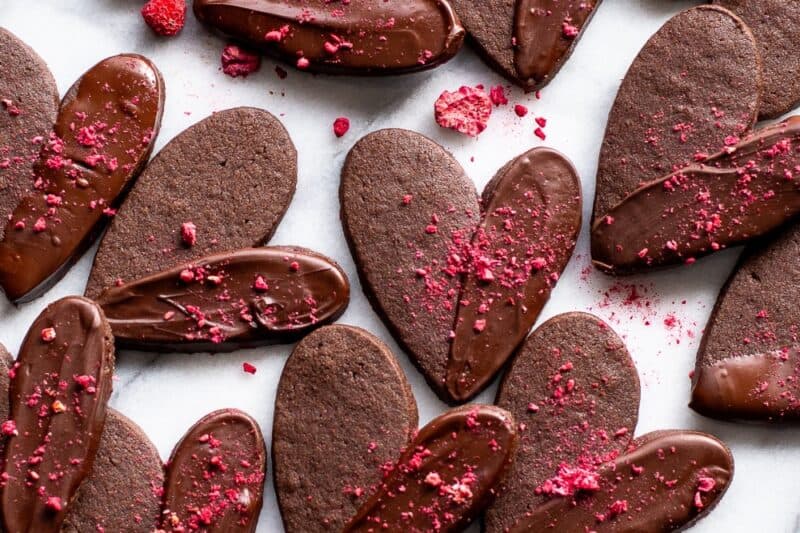 An overhead shot of a pile of chocolate heart shaped cookies