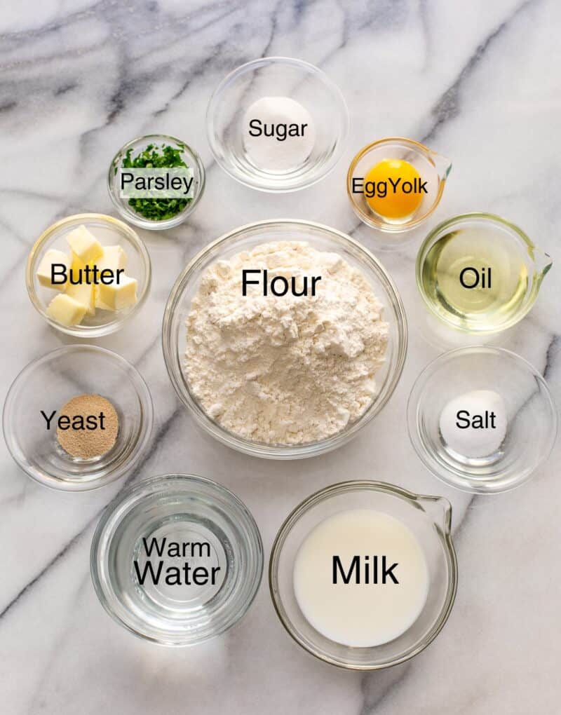 A collage of ingredients needed to make naan bread including flour, water, oil, salt, milk, yeast, butter, parsley, sugar and an egg yolk.