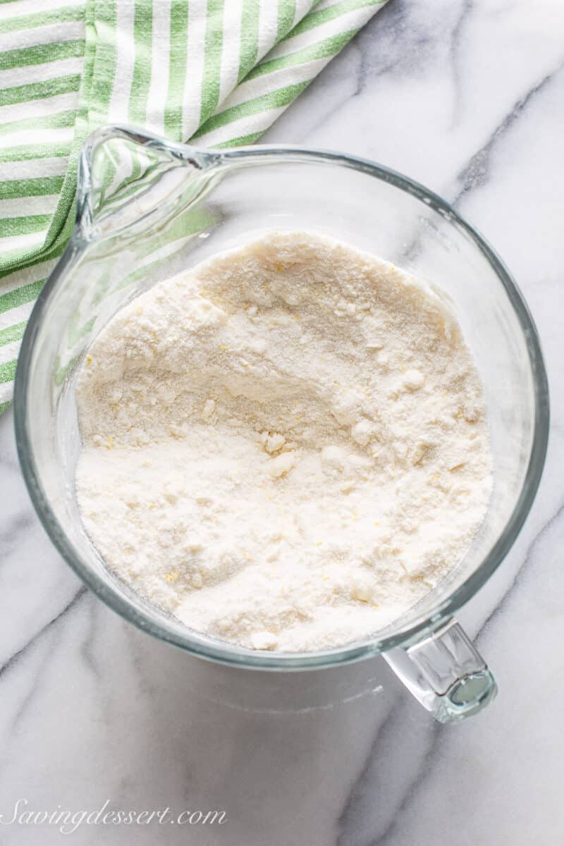 A mixing bowl with flour, sugar, butter and cream cheese mixed to pea sized pieces.