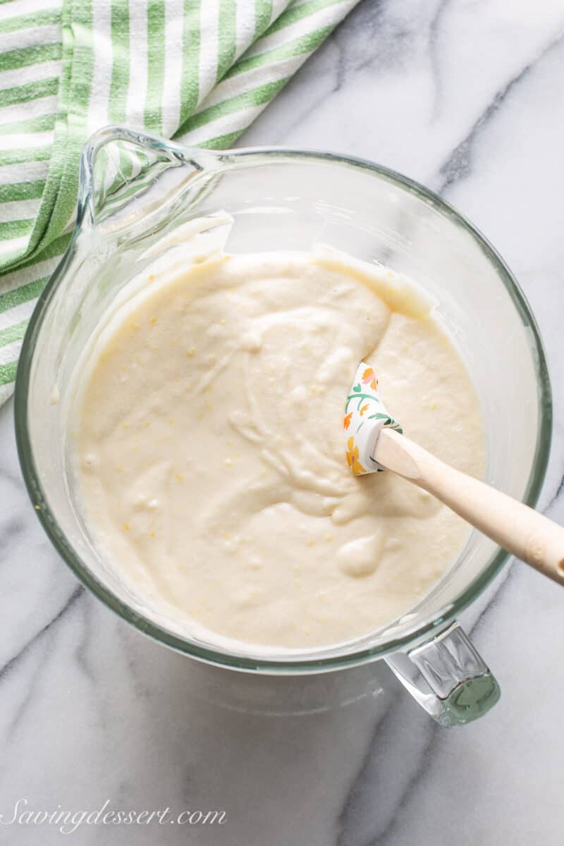 Lemon cake batter in a mixing bowl with a spatula.
