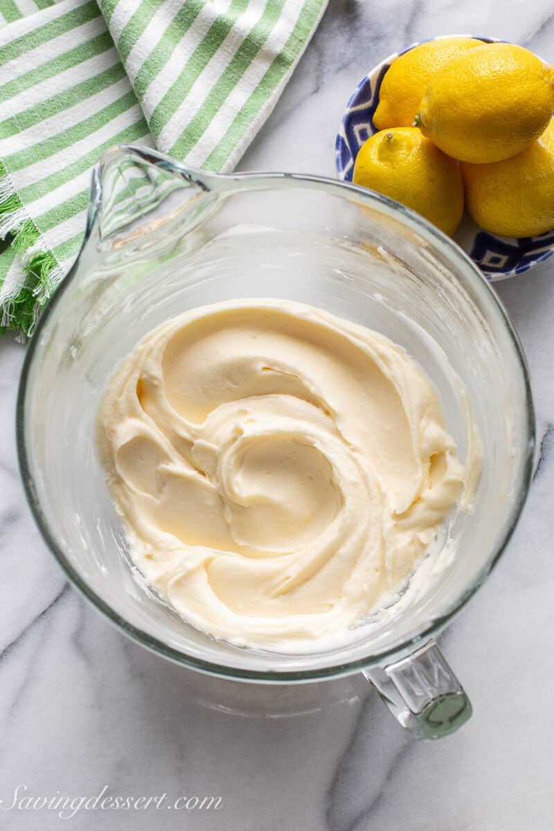 A mixing bowl filled with silky smooth lemon buttercream frosting.