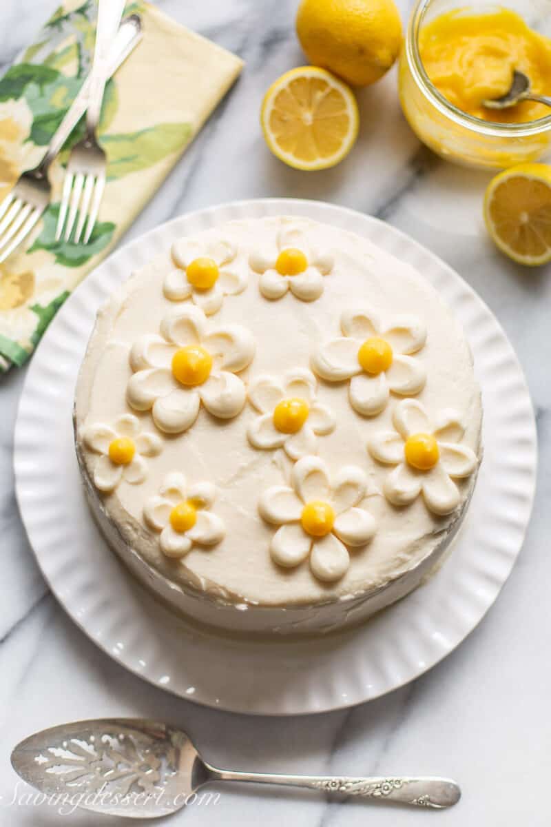 An overhead shot of a lemon curd cake topped with buttercream flowers with lemon curd centers.