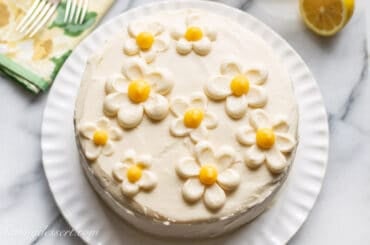 Lemon Curd Cake topped with flowers made from frosting and lemon curd.
