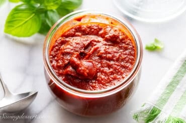 An overhead shot of a large wide mouth jar of homemade pizza sauce.