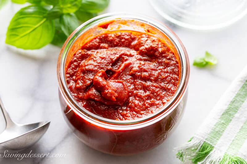 An overhead shot of a large wide mouth jar of homemade pizza sauce.