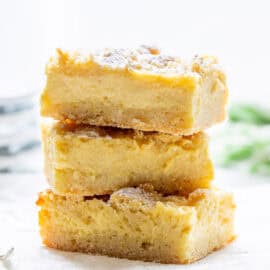 A stack of lemon crumb bars topped with powdered sugar.