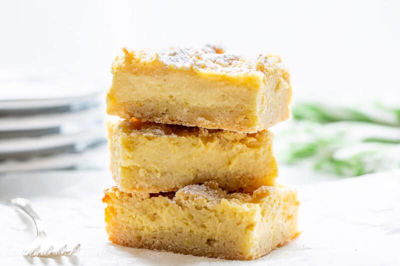 A stack of lemon crumb bars topped with powdered sugar.
