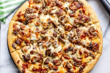 A closeup of a sliced mushroom pizza.