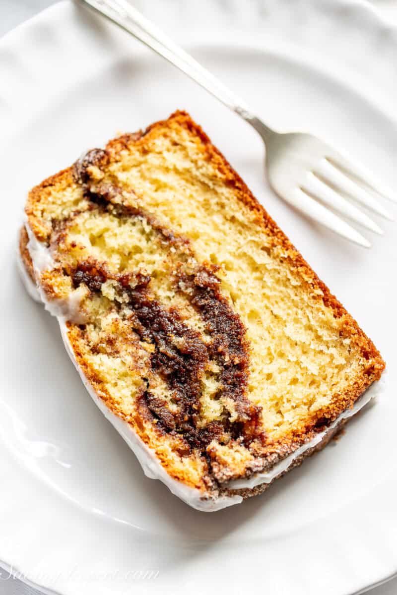 An overhead view of a slice of cinnamon quick bread on a plate with a fork.
