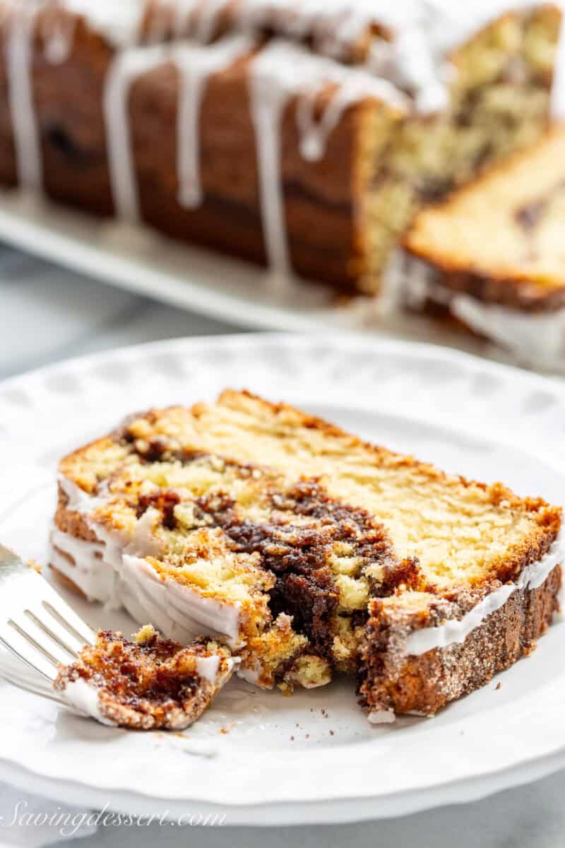A side view of a slice of cinnamon swirl quick bread with a corner removed.