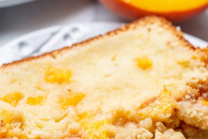 A closeup of a slice of peach cake on a plate.