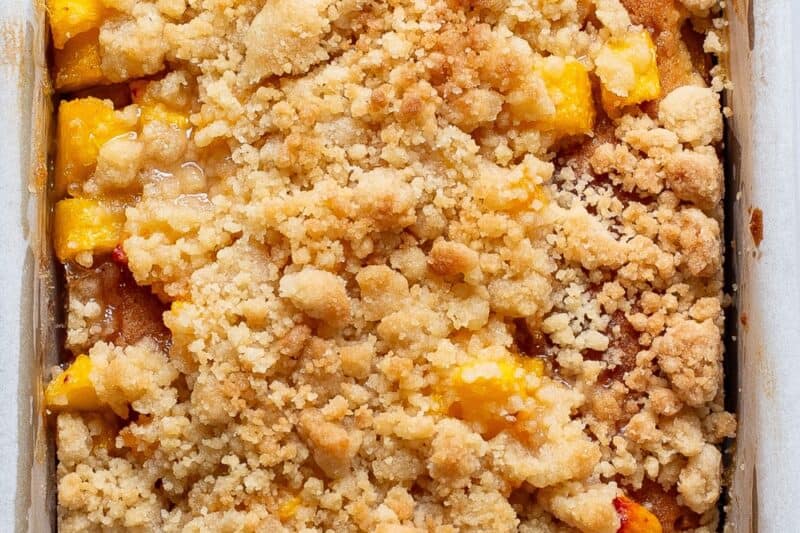 An overhead view of a peach crumble pound cake in a loaf pan.