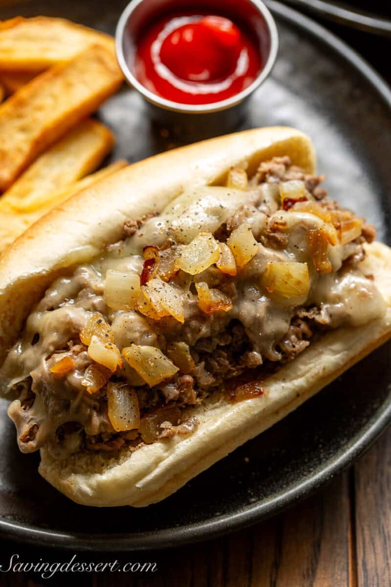 An overhead view of a steak sandwich topped with melted cheese and caramelized onions.