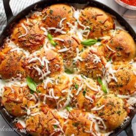 A skillet filled with pull apart pizza bread.