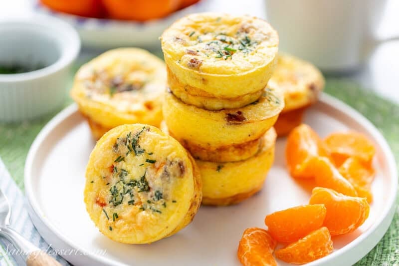 A stack of egg muffins on a plate with clementine sections.
