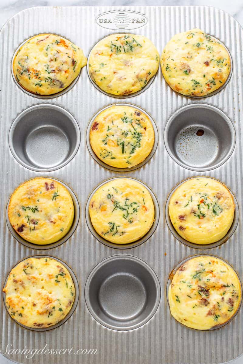 An overhead shot of a muffin tin with nine baked egg muffins.
