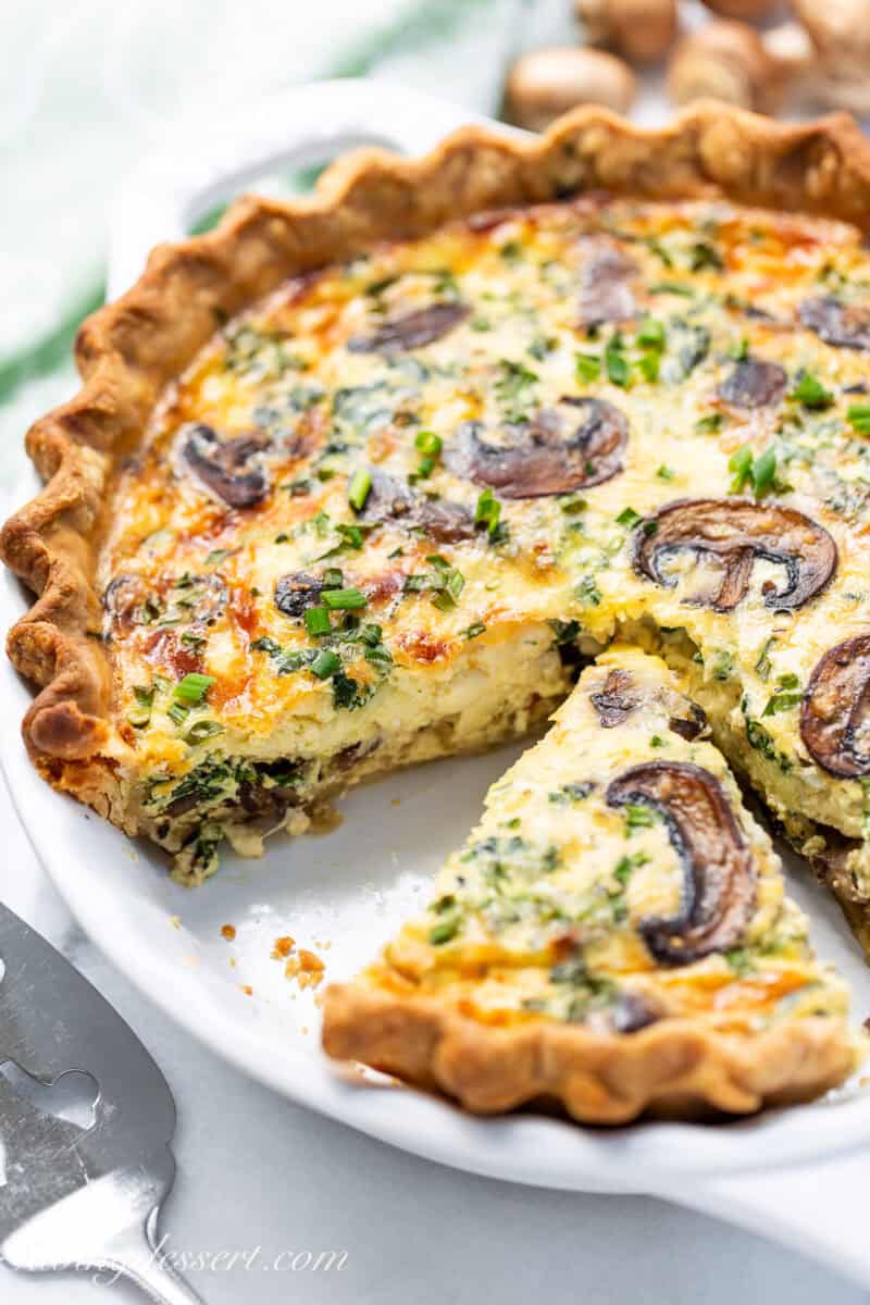 A sliced quiche with spinach and mushrooms.
