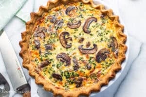 A spinach mushroom quiche baked to a deep golden brown.