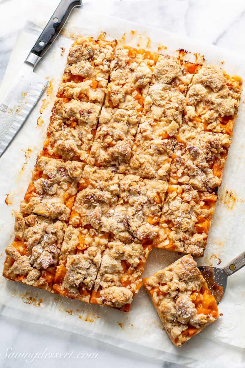 An overhead view of a pan of apricot bars cut into squares.
