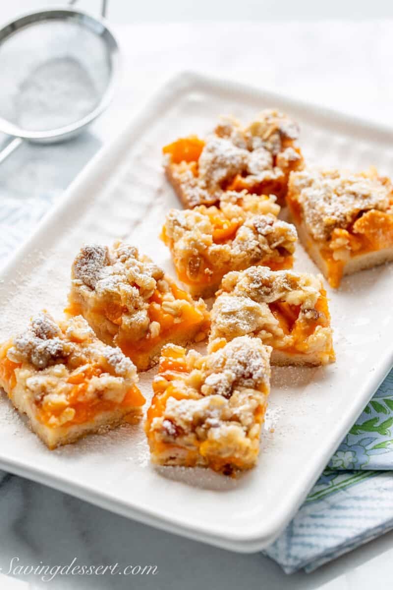 A small platter filled with apricot bars cut into small squares.