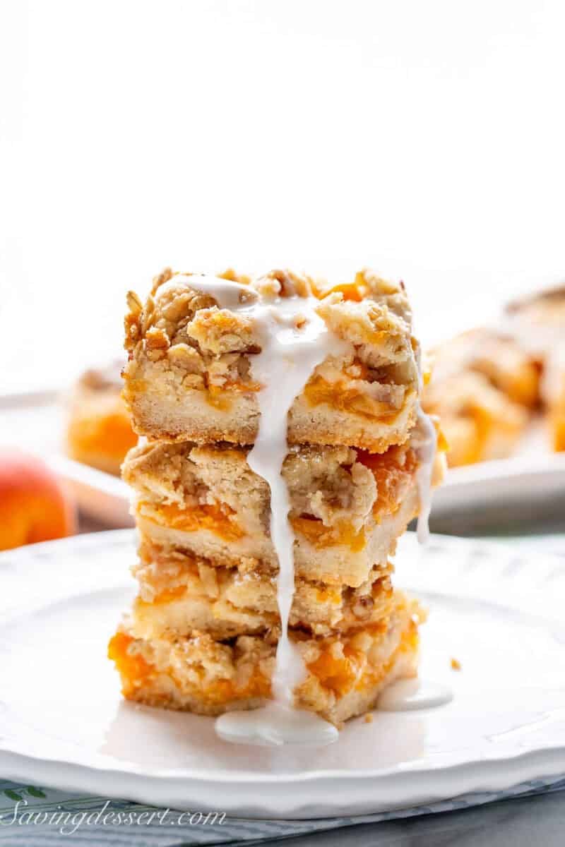 A stack of apricot bars with icing dripping down the sides.
