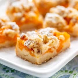 A closeup of a platter filled with apricot bars with a crumble topping.