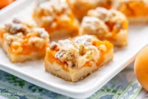 A closeup of a platter filled with apricot bars with a crumble topping.
