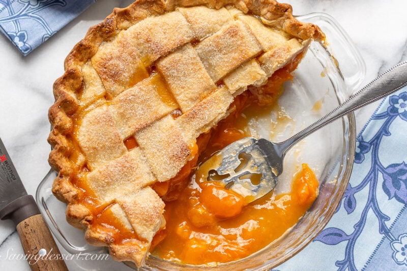An overhead photo of half a fresh apricot pie with a lattice crust on top.