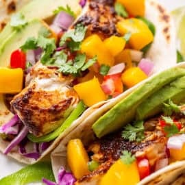 A closeup view of a fish taco with mango salsa.