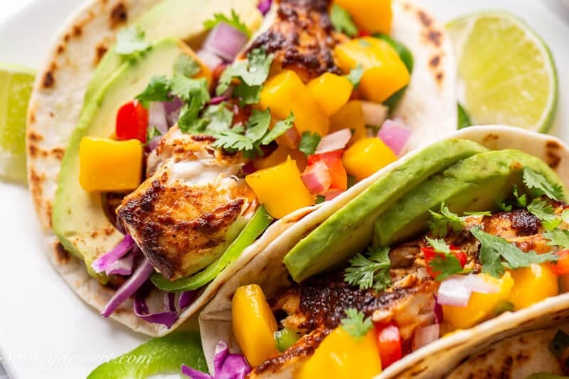 A closeup view of a fish taco with mango salsa.