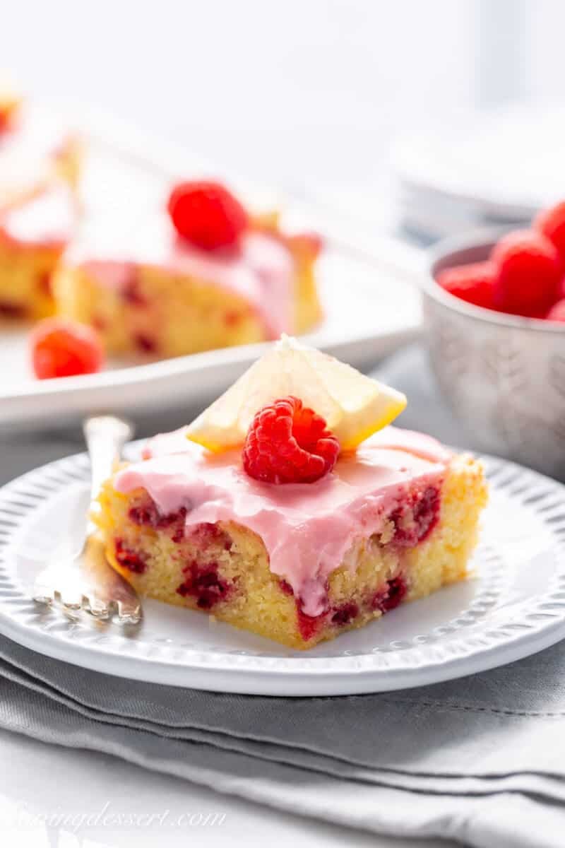 A small lemon raspberry bar with a fresh raspberry on top.