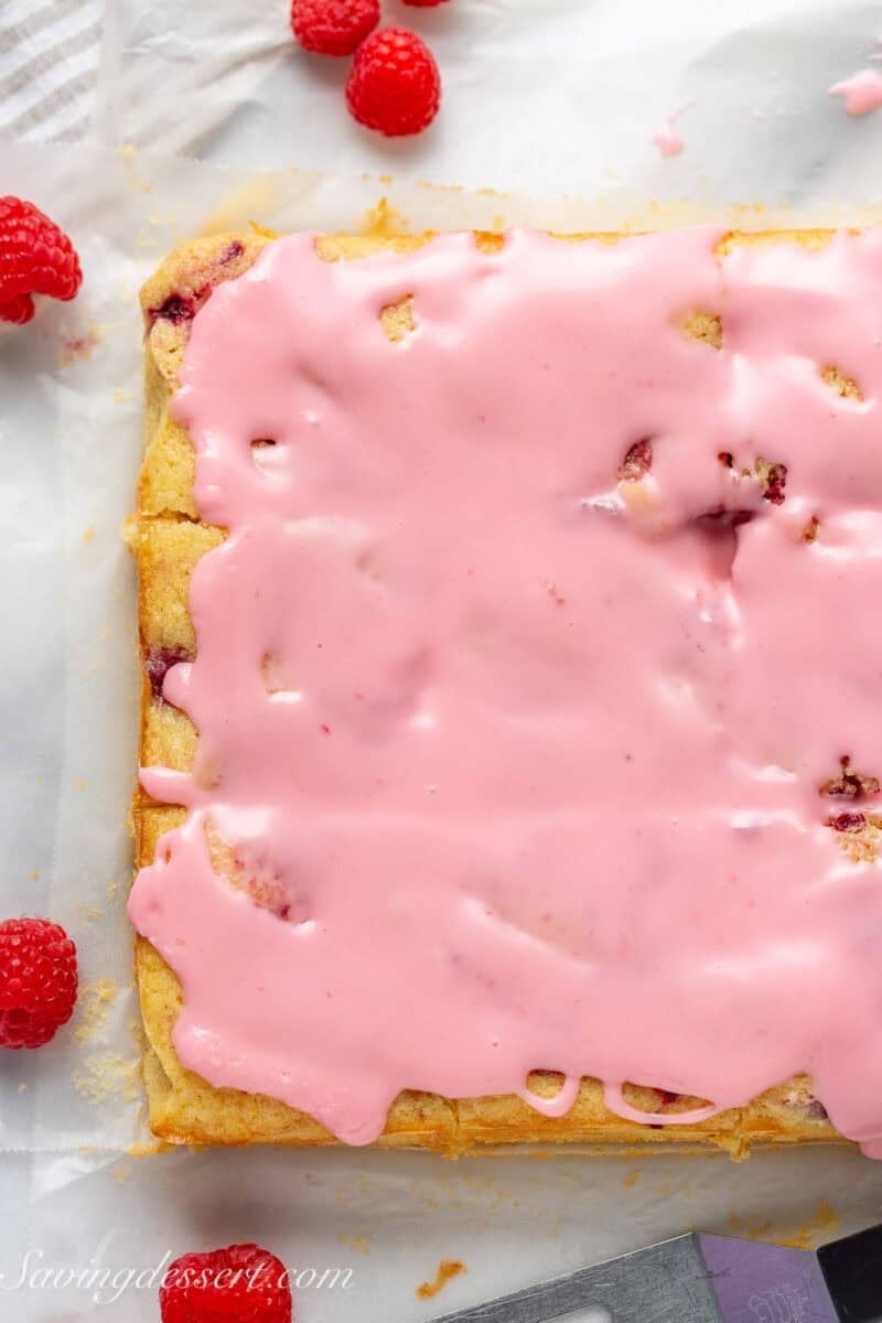 A pan of lemon raspberry bars with a raspberry icing drizzle on top.