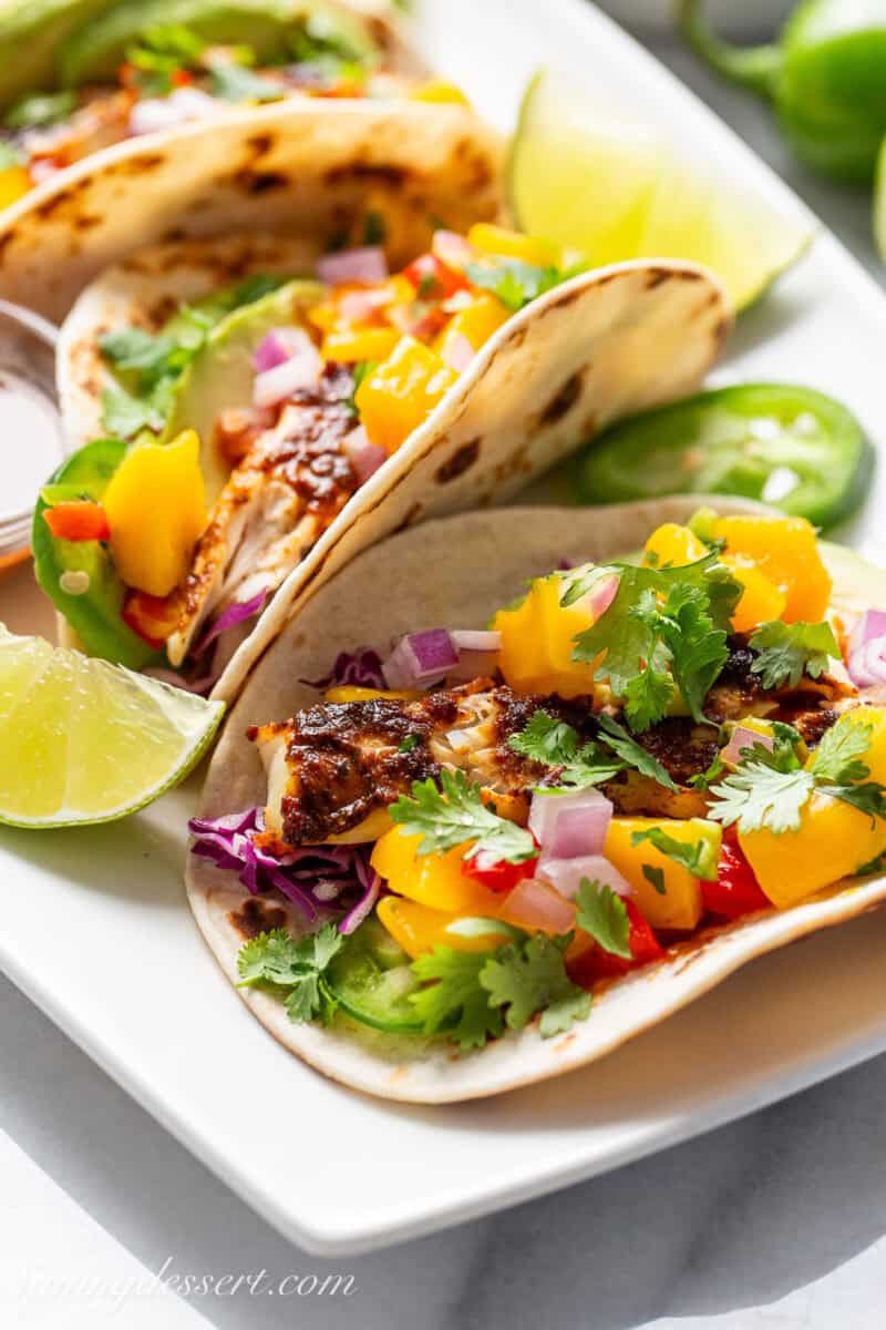 Fish tacos on a platter with mango salsa.