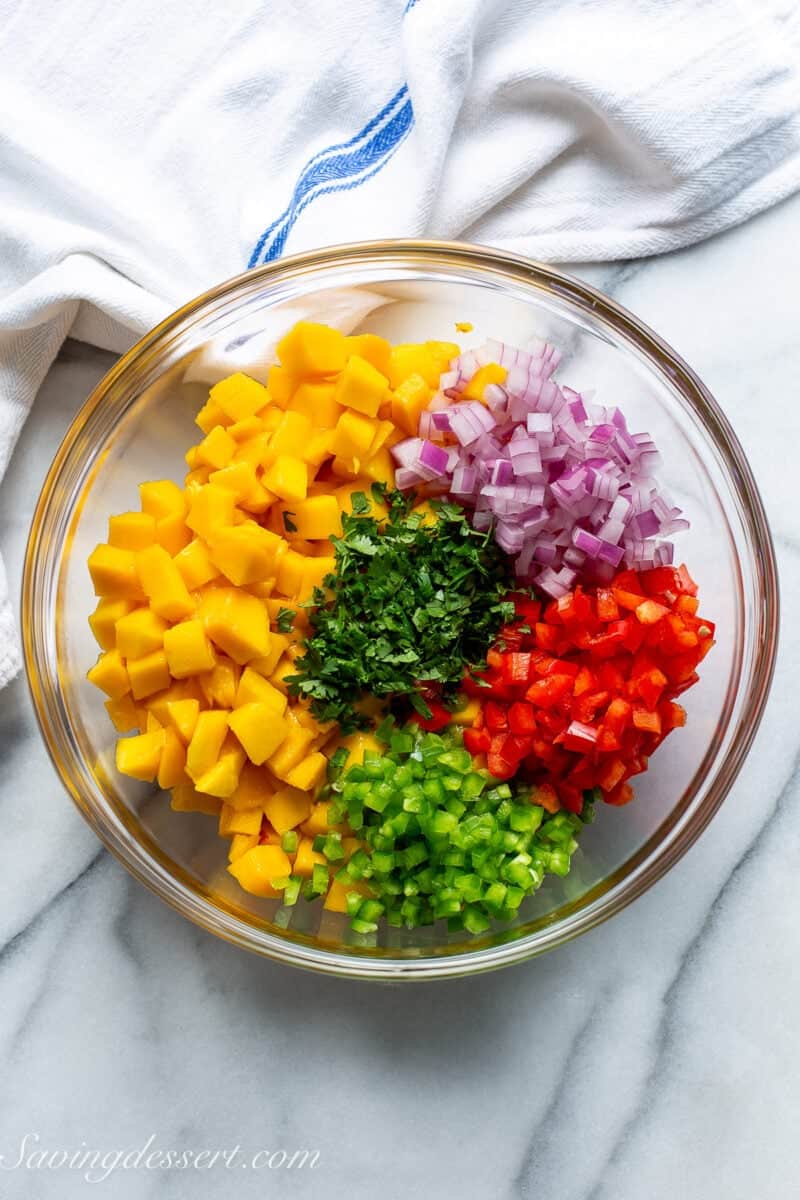 A bowl of chopped ingredients for mango salsa.