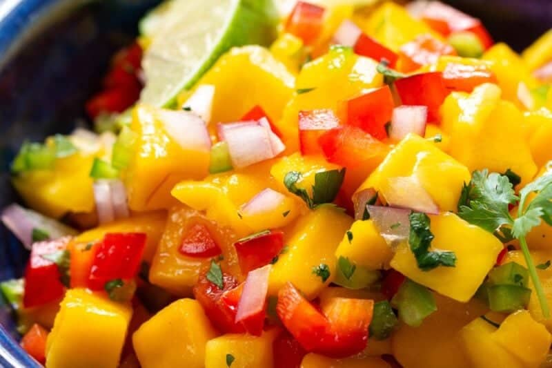 A closeup of a bowl of mango salsa with cilantro.