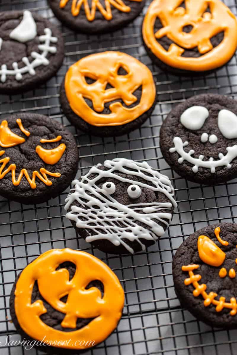 A closeup of chocolate cookies decorated for Halloween in various spooky themes.