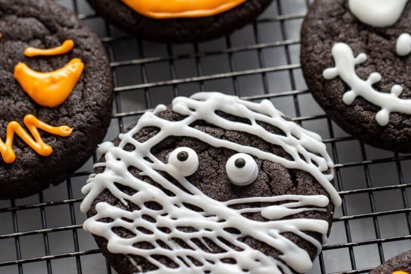 A closeup photo of decorated Halloween cookies on a rack.