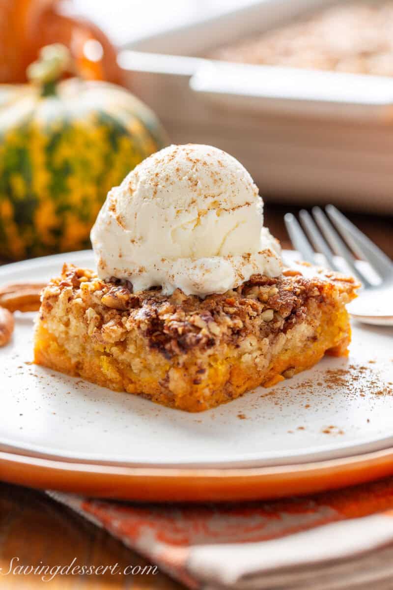 A side view of a piece of pumpkin dump cake on a plate.