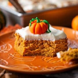 A piece of pumpkin cake on a plate with a fork.