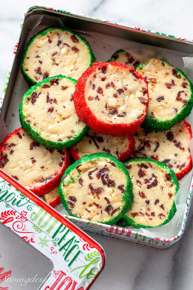 A Christmas tin filled with shortbread cookies rolled in red and green sanding sugar on the edges.