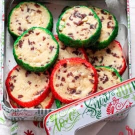 A Christmas tin filled with cranberry shortbread cookies trimmed in red and green sanding sugar.
