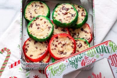 A Christmas tin filled with cranberry shortbread cookies trimmed in red and green sanding sugar.