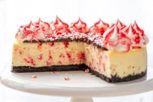 A side view of a peppermint cheesecake with several slices cut out.