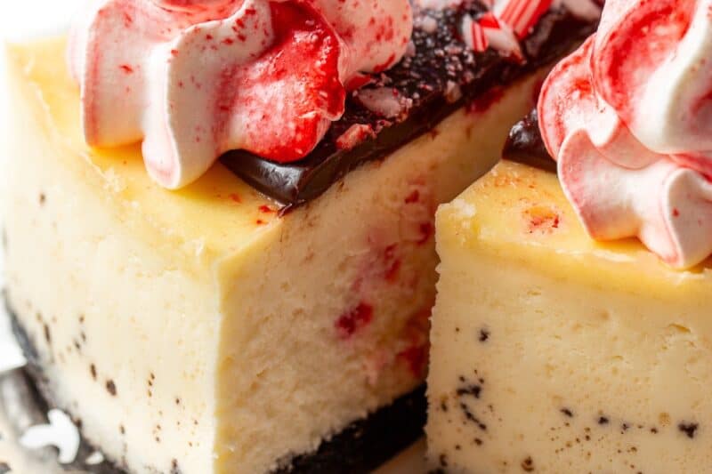 A slice of peppermint cheesecake being removed from the cake.