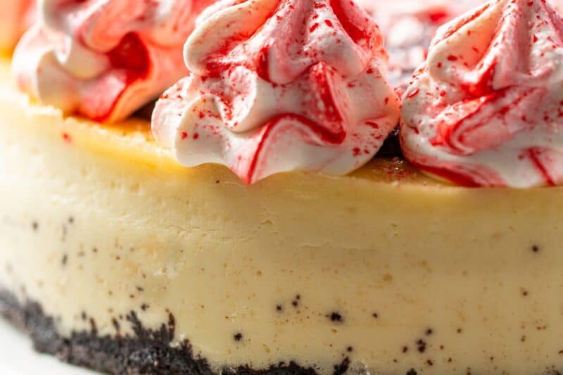 A side view of a peppermint cheesecake on a cake plate.