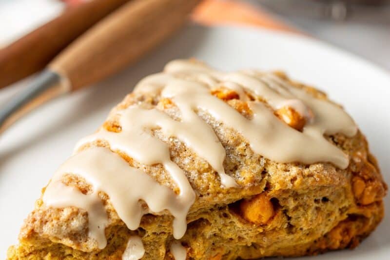 A pumpkin scone with a maple glaze drizzled on top.