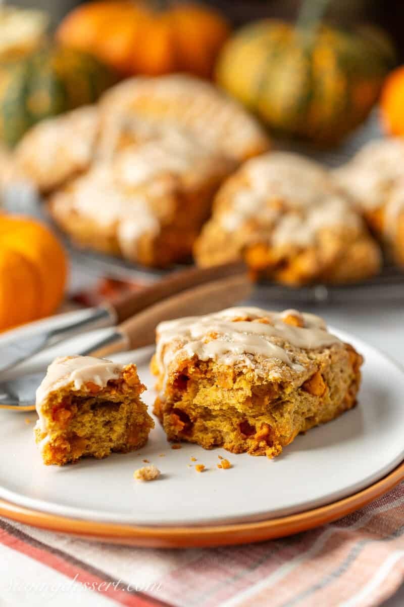 A pumpkin scone with the tip broken off to show the soft interior.