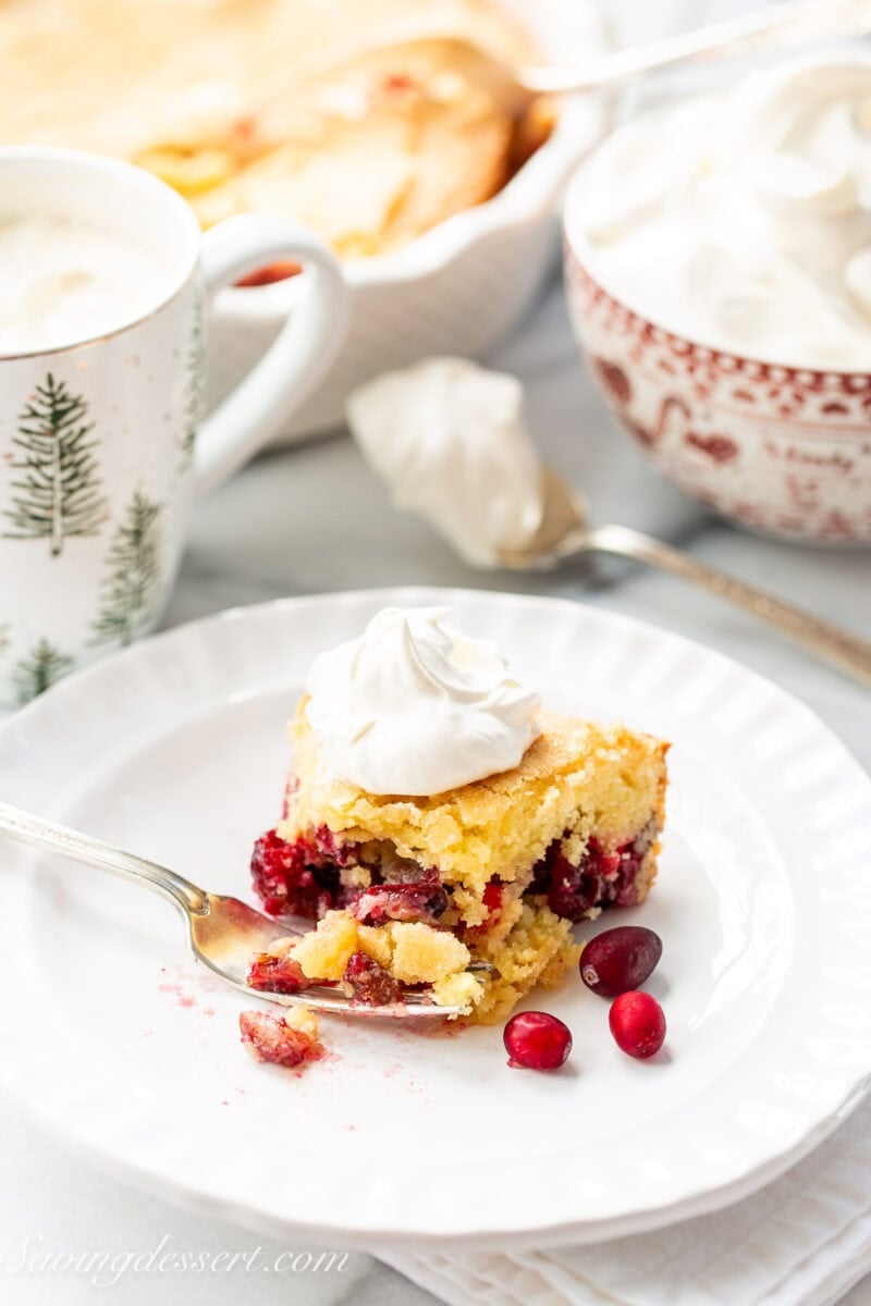 Nantucket Pie on a plate with a fork and topped with whipped cream.